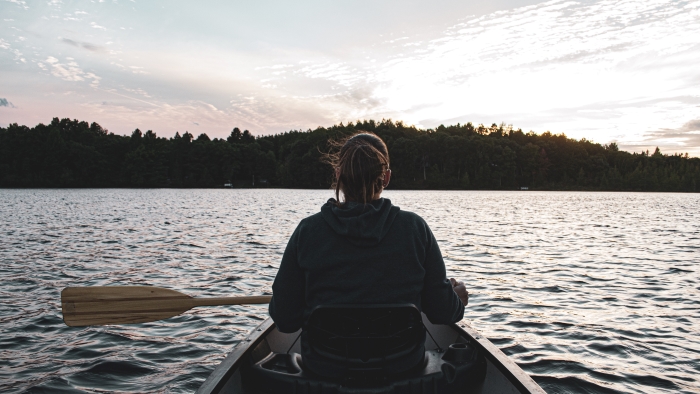 Person kayaking on a serene lake